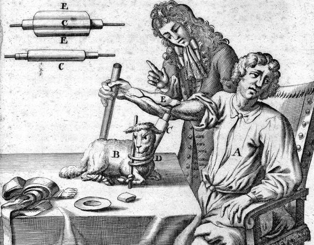 Engraving of a man at a table with another man standing next to him giving instruction. On the table is a small animal and a series of tools with letter labels.